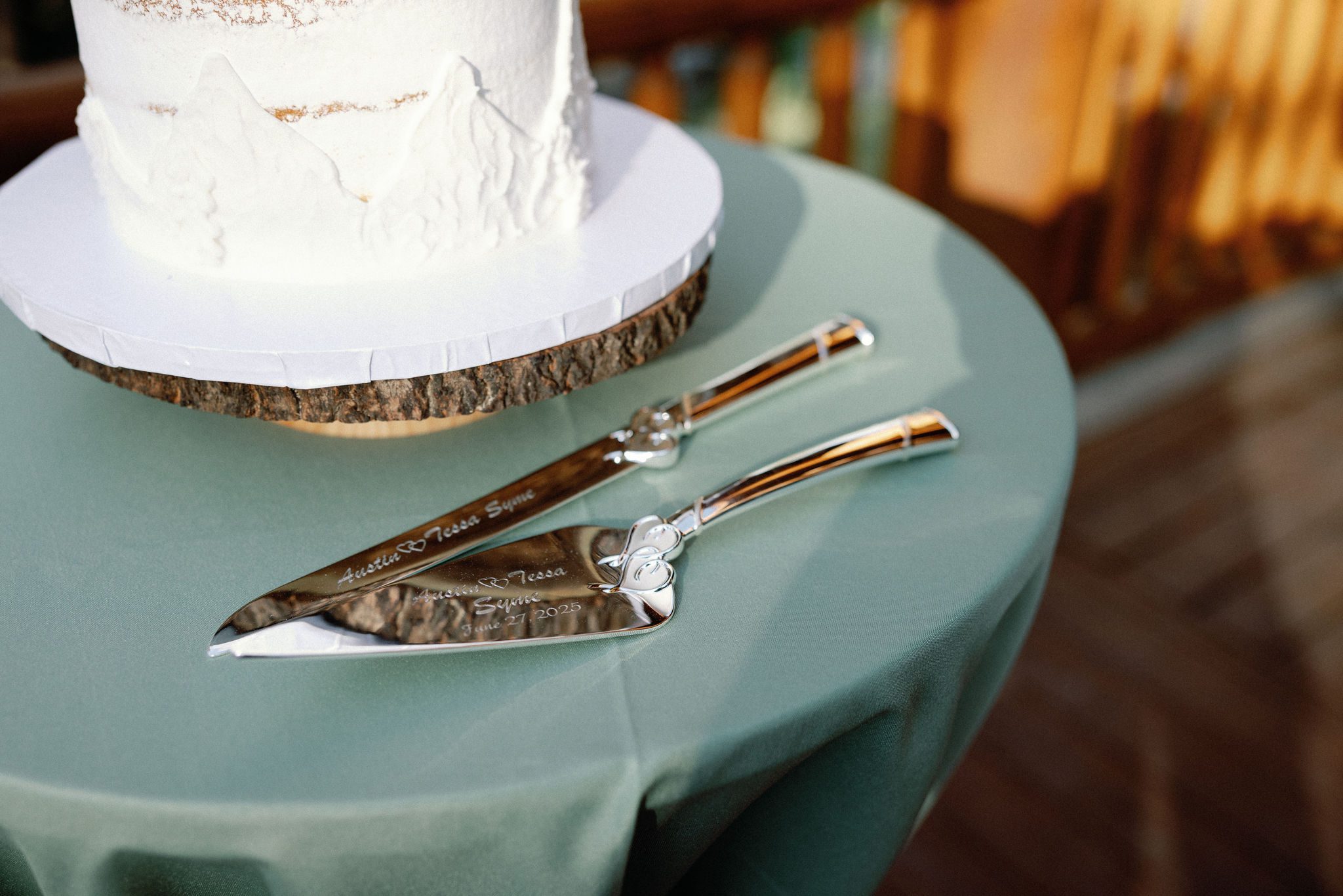 white wedding cake sits next to custom cake cutting utensils 