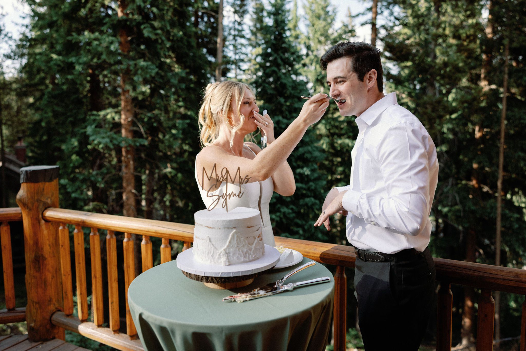 bride and groom feed each other a bite of wedding cake on the deck of the airbnb