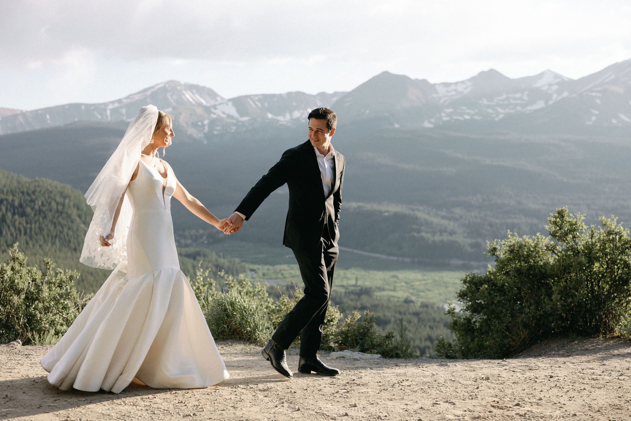 bride and groom walk hand in hand at boreas pass after ceremony at colorado airbnb wedding