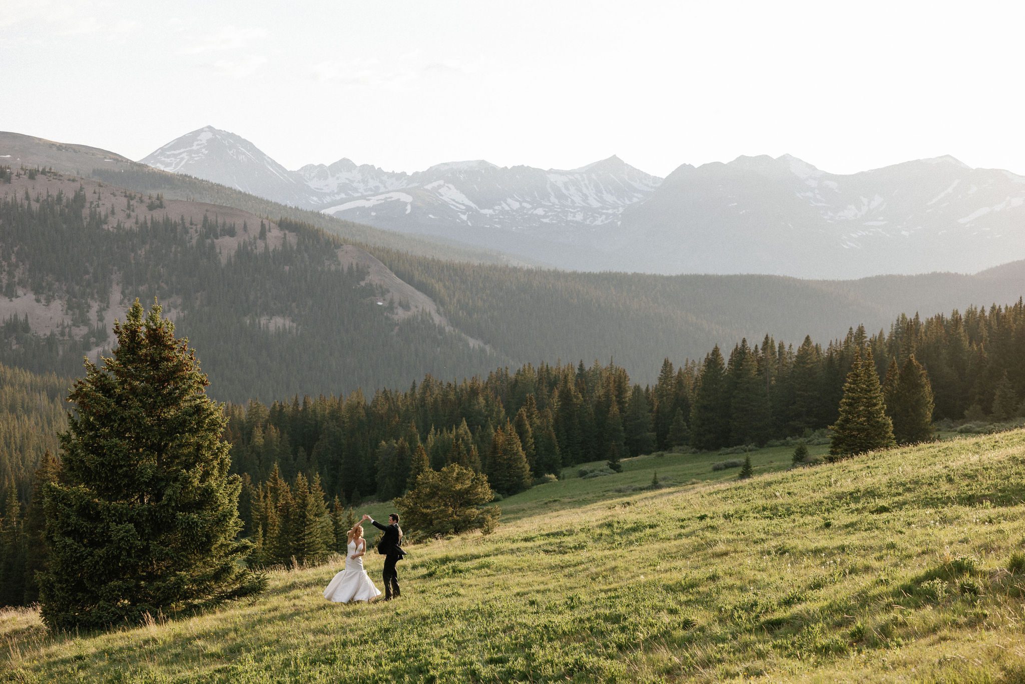 after colorado airbnb wedding, bride and groom dance in the mountains during sunset