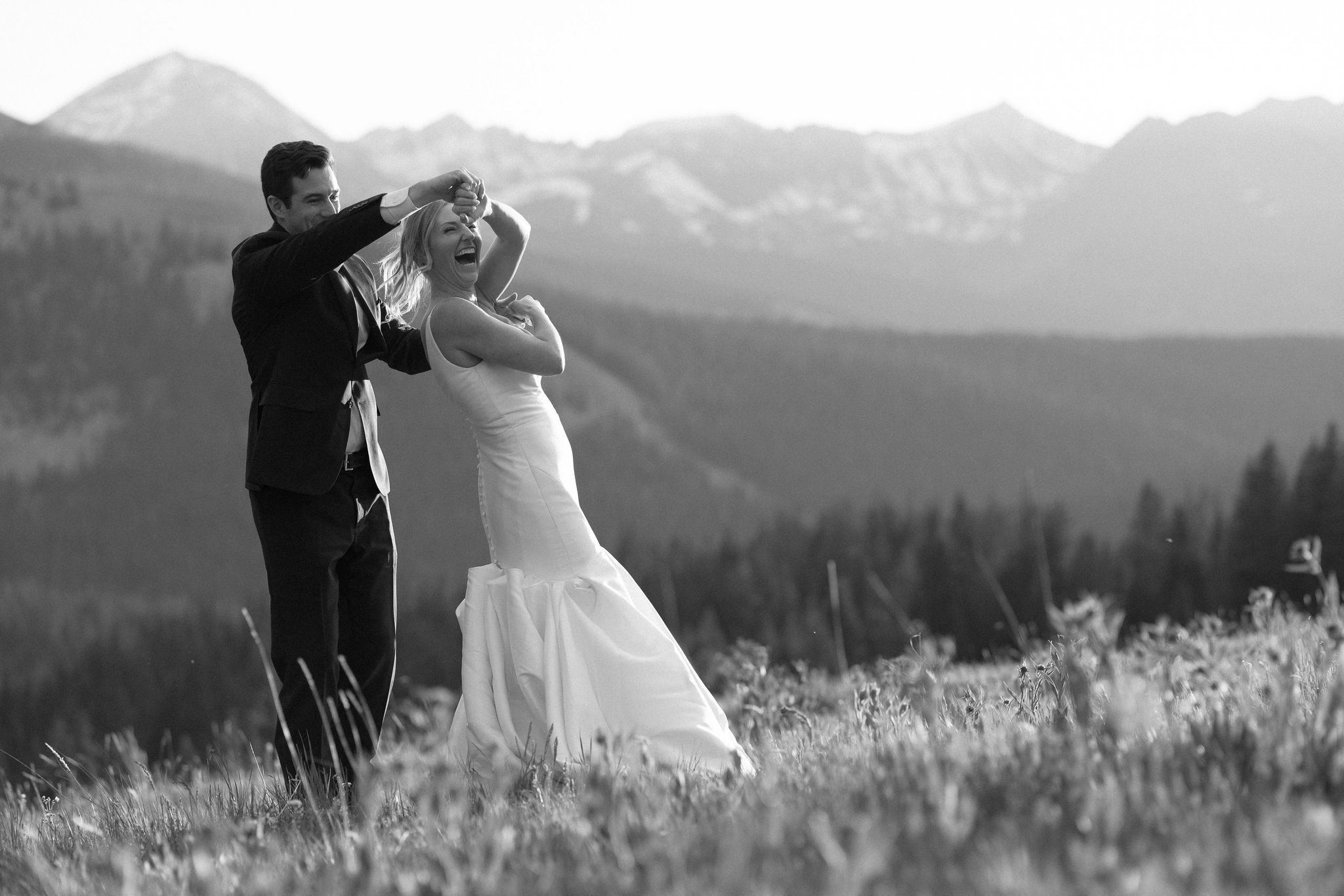 bride and groom laugh while dancing during sunset wedding photos in the colorado mountains