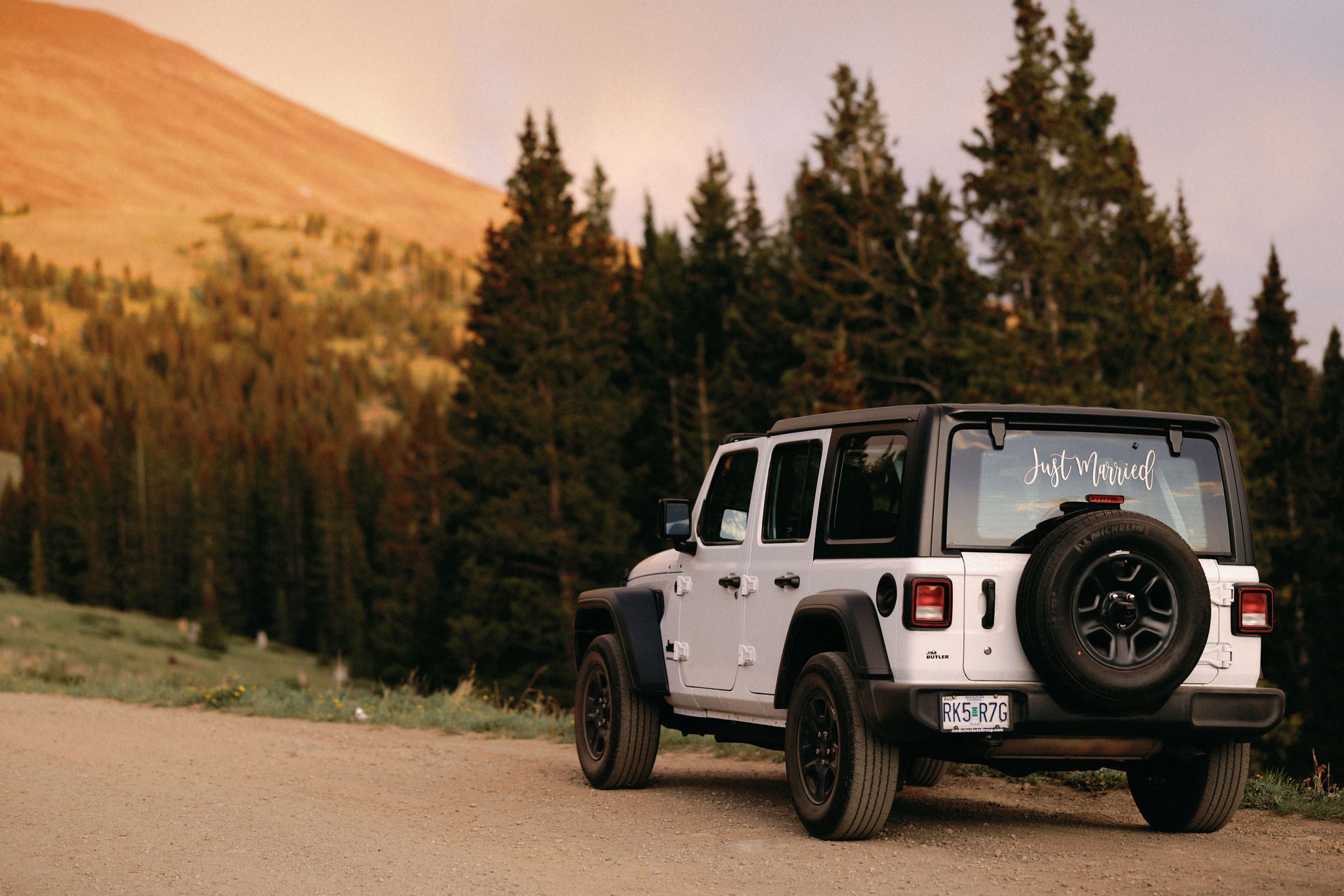 white jeep with 'just married' decal on the back window during sunset