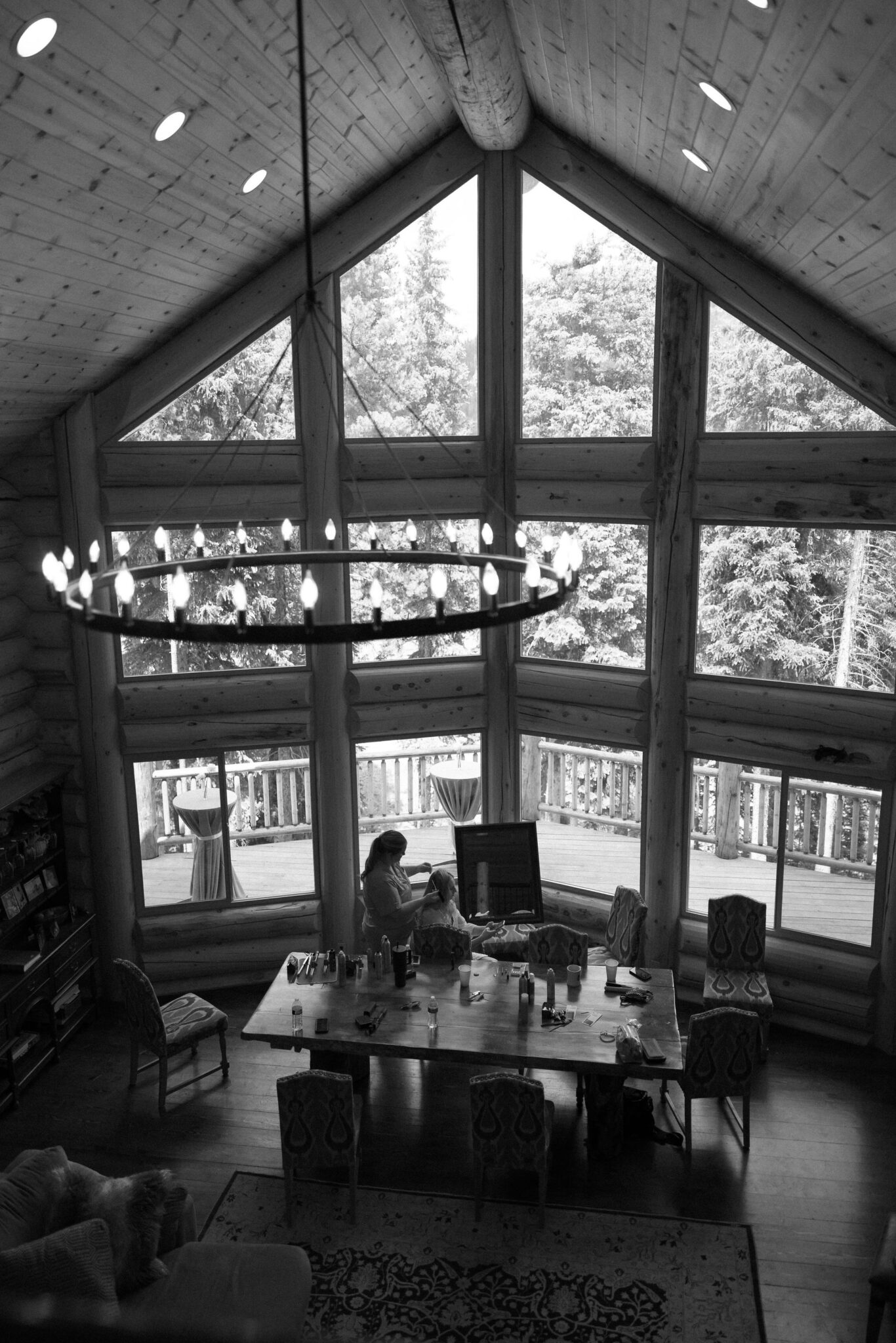 bride gets ready for her wedding in the living room of the airbnb, in front of a huge window looking out into the mountains.