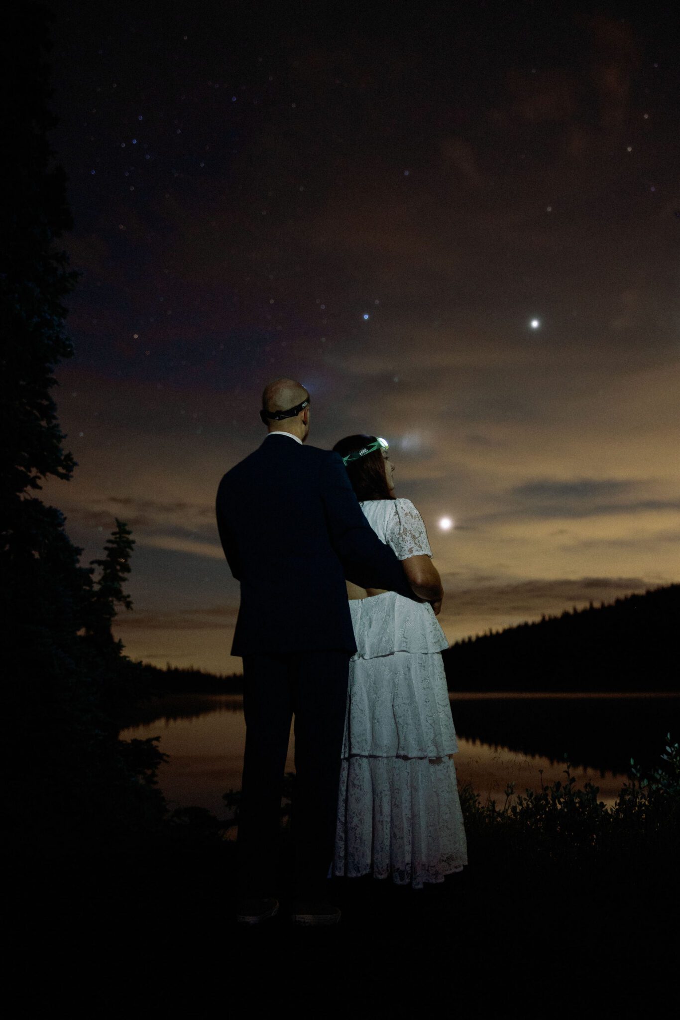 bride and groom stand and embrace during their sunrise hike for their wedding