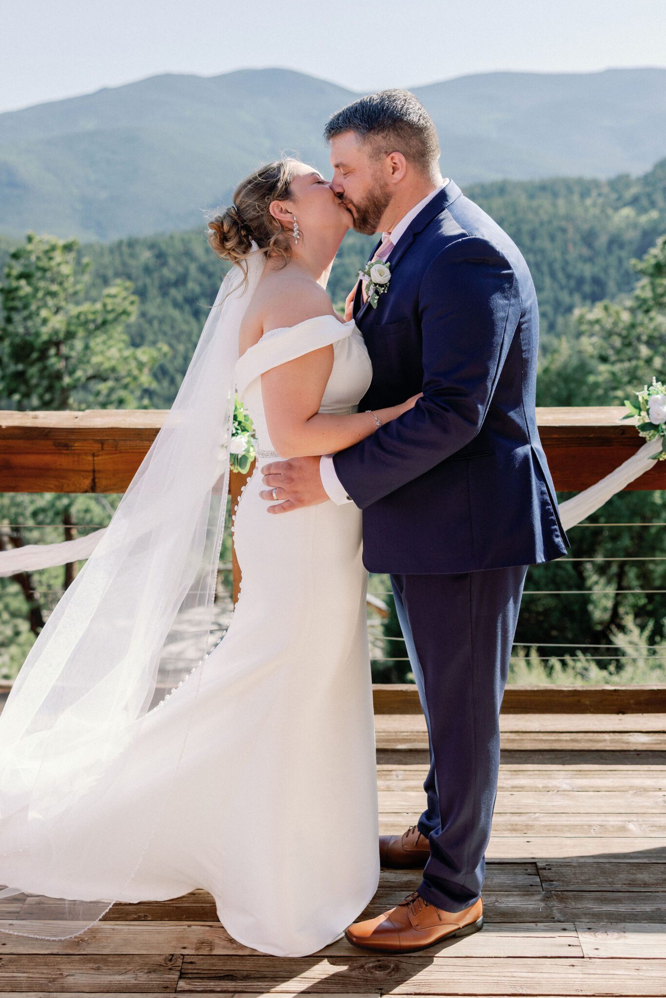 bride and groom kiss while on the deck of an airbnb, their colorado elopement location