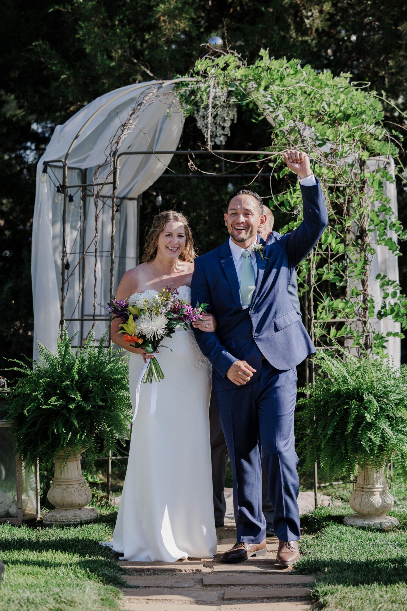 bride and groom celebrate before they walk down the aisle after getting married