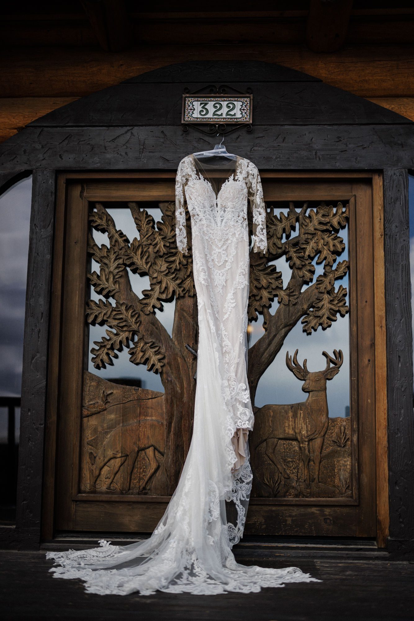 wedding dress hangs on the wooden door of a cabin airbnb 