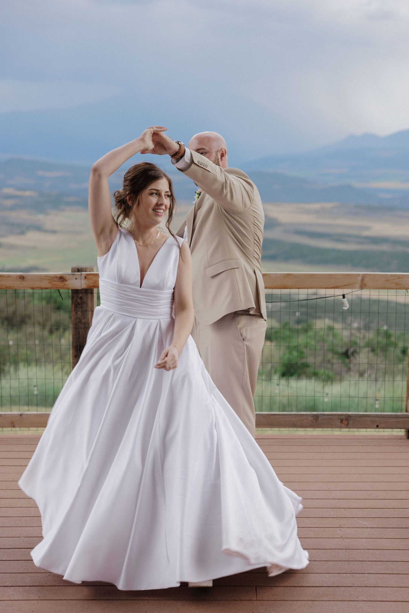 at their colorado elopement location, a VRBO, bride and groom dance on the deck