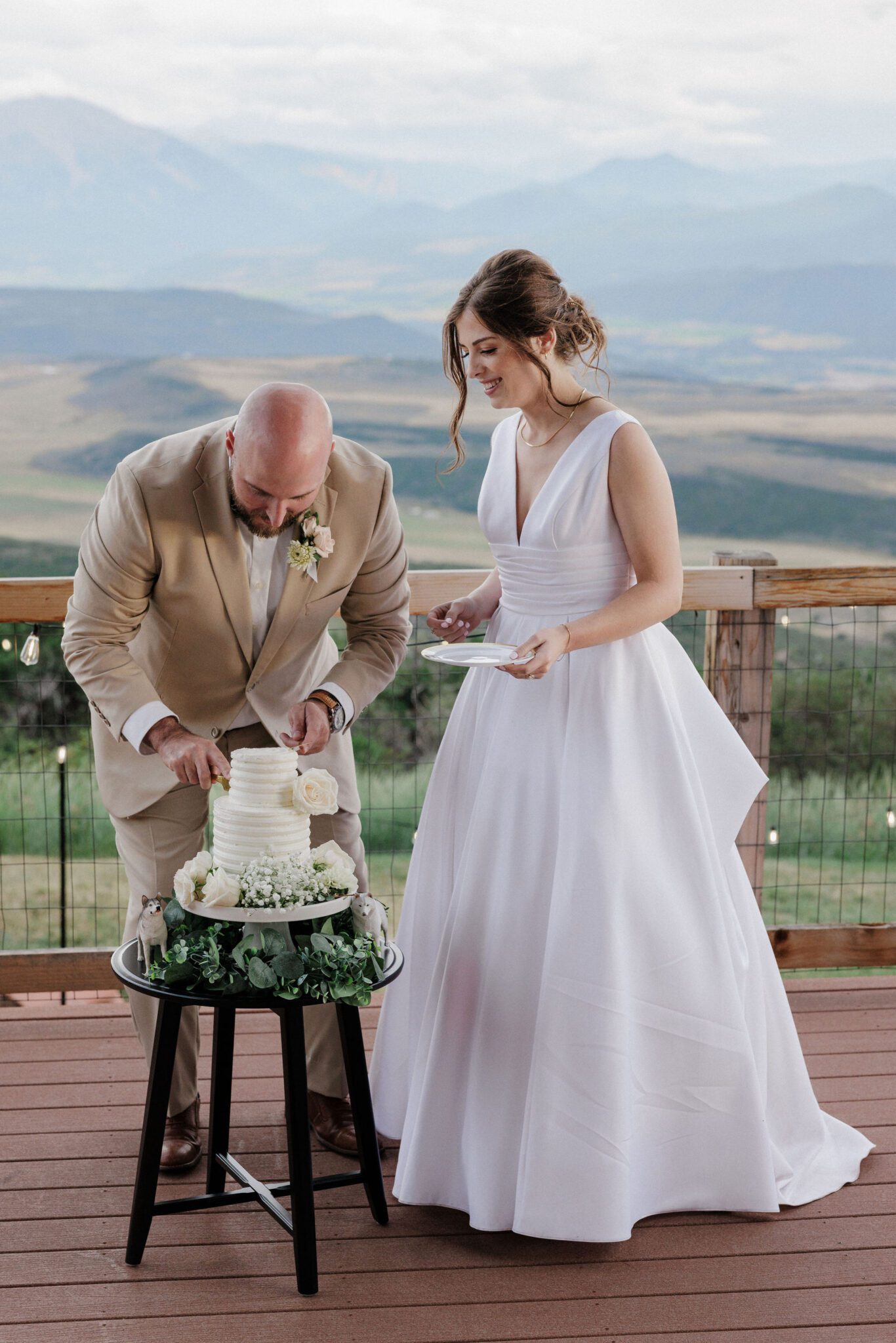 bride and groom cut the wedding cake on the deck of their airbnb, their colorado elopement location