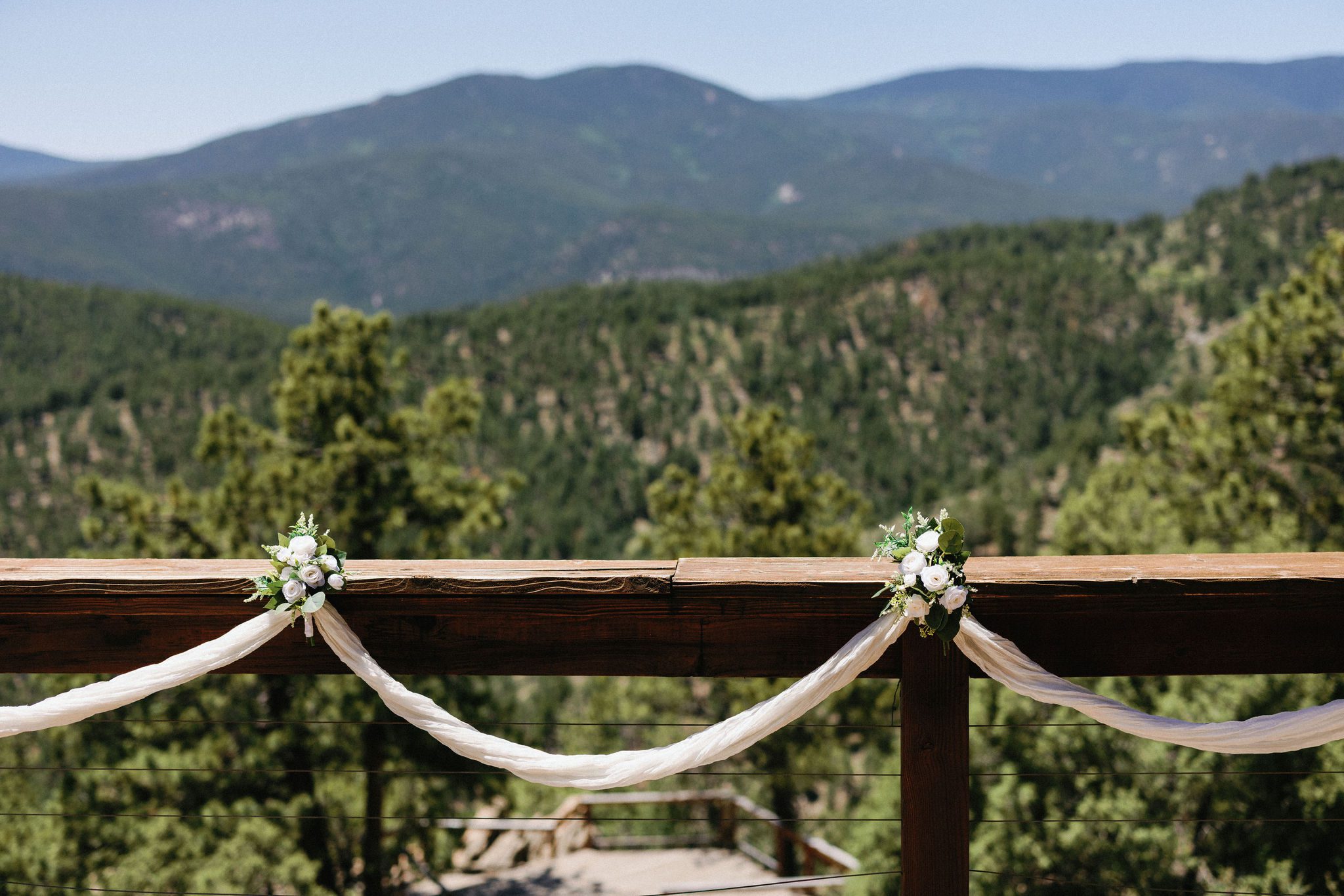 white flowers and fabric hang on the railing of the airbnb deck